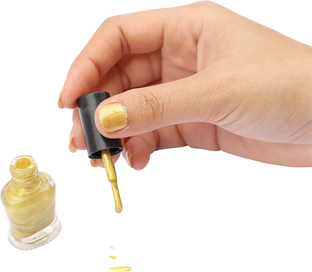 close up hand holding gold nail polish